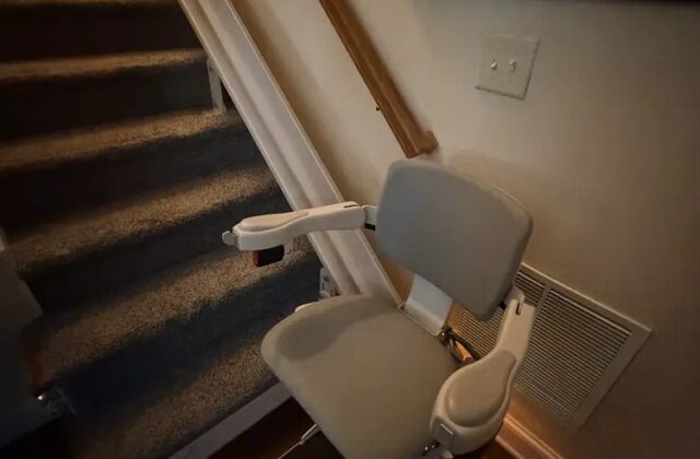 Bruno Elite curved stairlift (CRE-2150) installed at the foot of a carpeted staircase