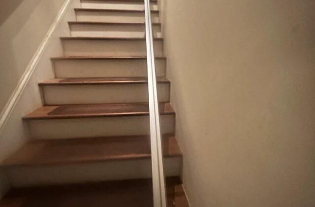 Bruno stairlift rail on a long staircase with the chair parked at the top