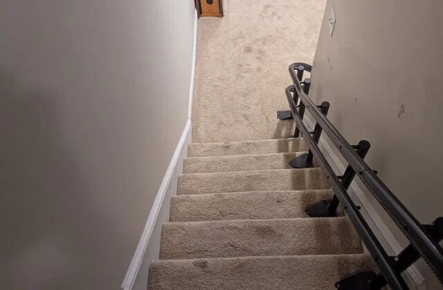 Handicare stairlift rail along carpeted stairs, viewed from the top