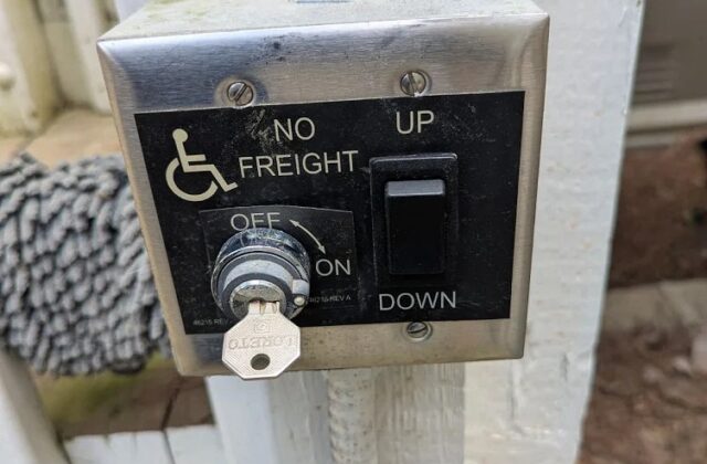 Harmar vertical platform lift call station with a key switch and up and down buttons on a post