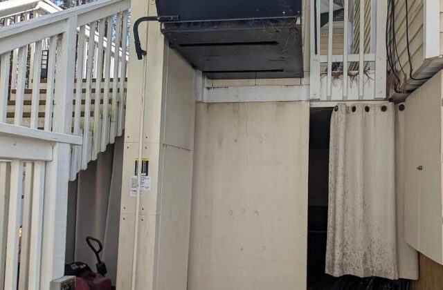 Harmar outdoor vertical platform lift running up the side of a raised deck