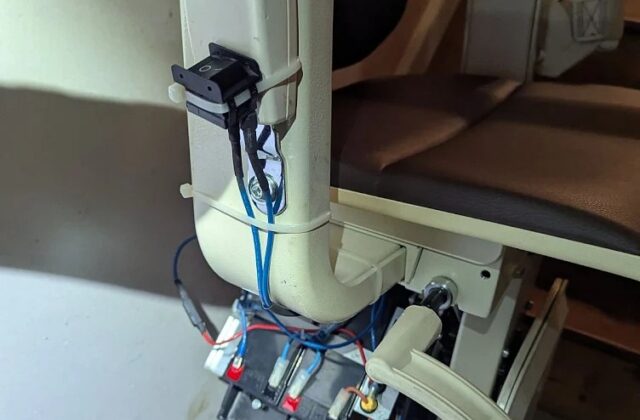 Handicare curved stairlift carriage opened up on the rail, wiring exposed during service