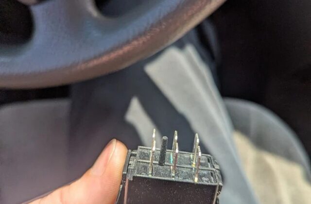 Harmar vertical platform lift switch held in a hand during a repair