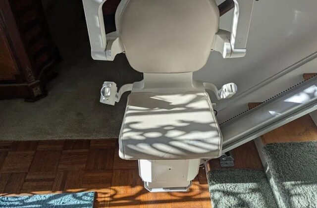 Handicare stairlift seat at the foot of the stairs, seen from above, on a service visit